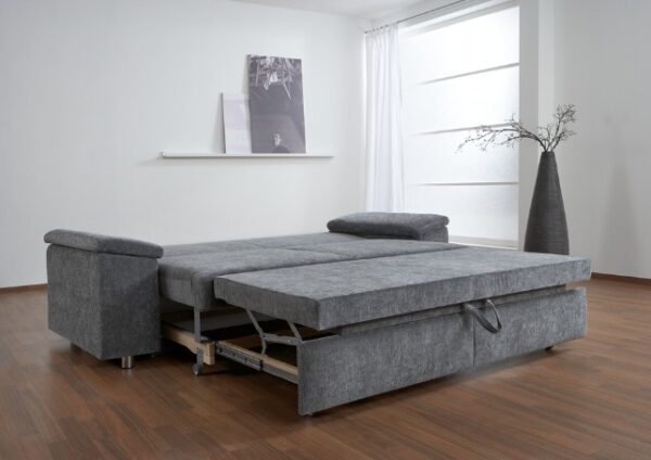 Grijze slaapbank uitgeklapt tot bed in moderne woonkamer met houten vloer