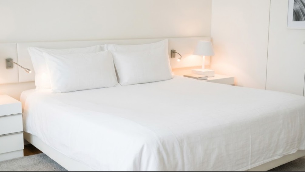 Brandvertragend wit bedtextiel van Bremafa op een opgemaakt hotelbed